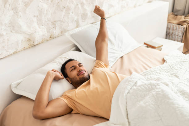 istock Wellslept Middle Eastern Man Awakening Stretching Arms Lying In Bedroom 1466358491