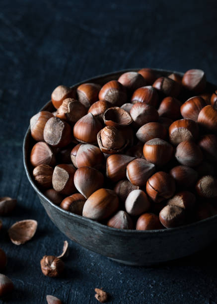 istock Hazelnut in a metal glass on a wooden background in rustic style. Raw hazelnuts. 1466358801