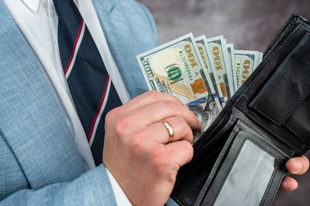 istock Businessman hands holding black leather wallet with dollar bills 1466359060