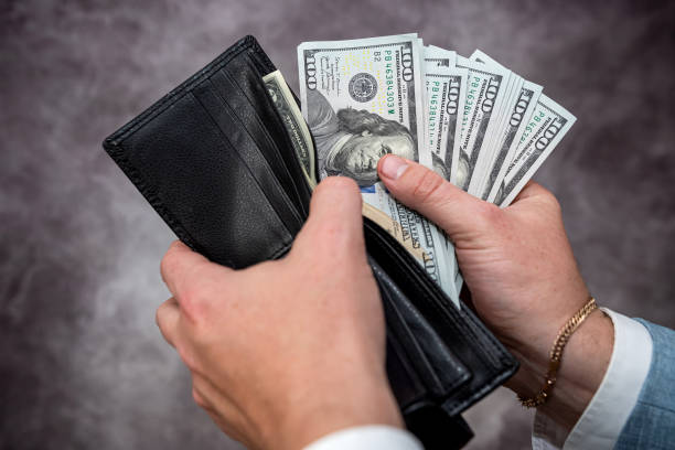 istock Businessman hands holding black leather wallet with dollar bills 1466359083