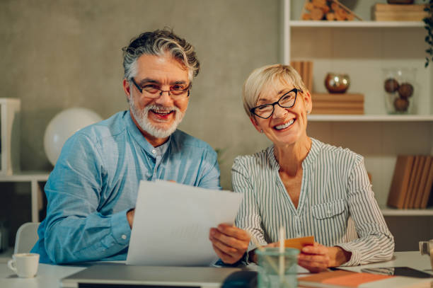 istock Senior couple checking their finances while sitting at the table at home 1466359180