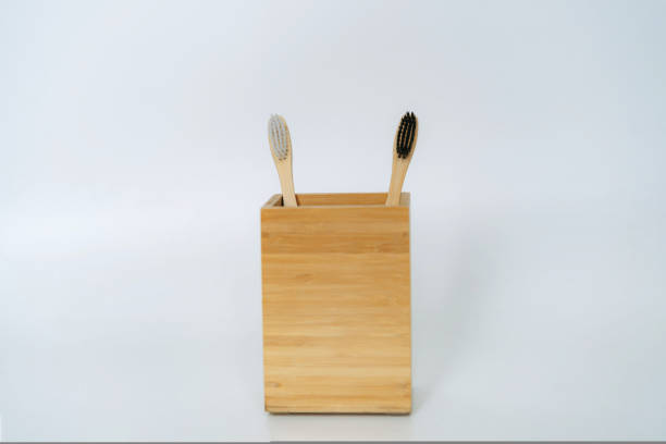 istock two toothbrushes in bamboo holder on white background 1466359460