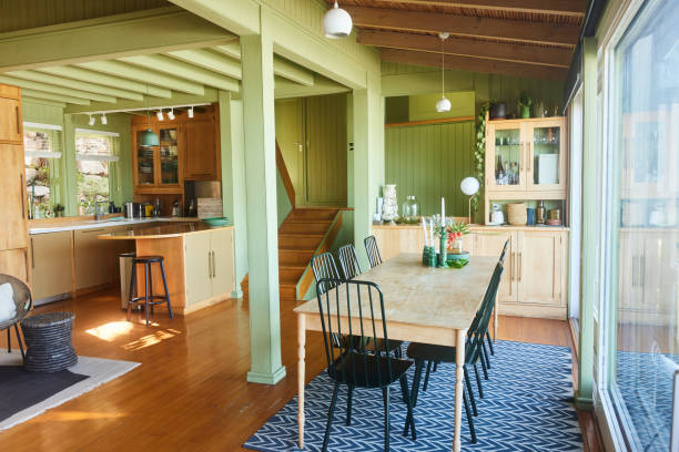 Table and chairs sitting by a patio window in the dining room of a rustic open plan vacation home
