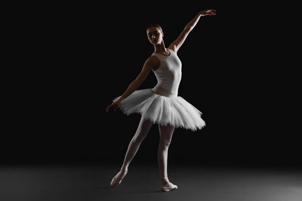 istock Young ballerina practicing dance moves on black background 1466363042