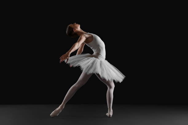 istock Young ballerina practicing dance moves on black background 1466363048