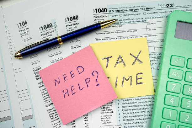 istock Text  TAX TIME with memo empty tax forms 1040 with pen calculator on desk 1466363722