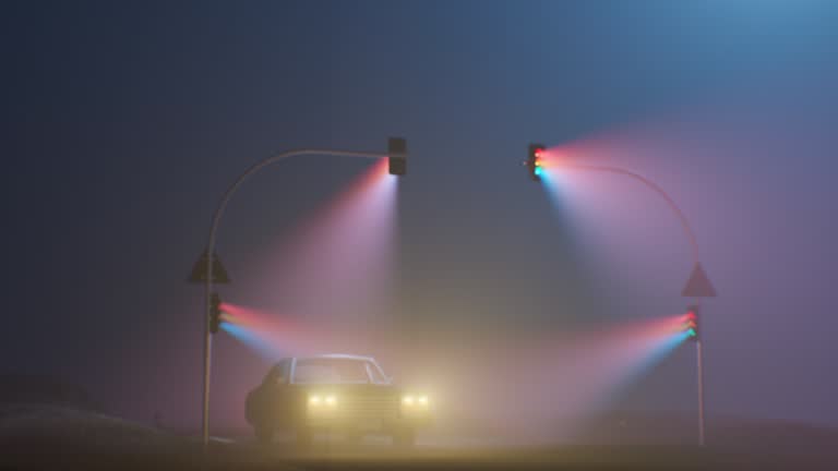 A car drives through the fog on a highway, illuminated by the light emanating from three traffic lights. The mist obscures the road, creating an eerie atmosphere as the car makes its way through the dimly lit environment.