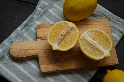 Lemons on cutting board on a wooden table