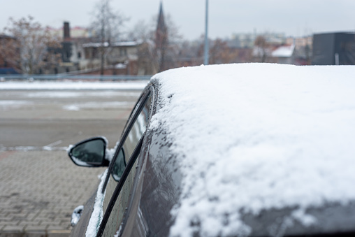 The onslaught of winter and snow for motorists. Snow on the car, windshield, car mirrors.