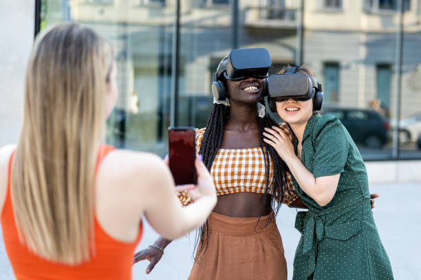 istock Young multiracial girls using futuristic virtual reality headset, having fun outdoors with technology and augmented reality online 1466373832