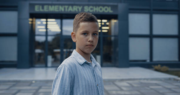 istock Upset elementary age boy standing at schoolyard closeup. Portrait unhappy pupil. 1466374896