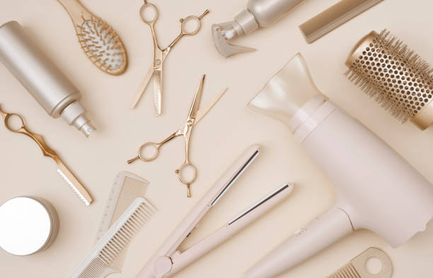 Various hairdresser tools flat lay on pink background top view stock photo