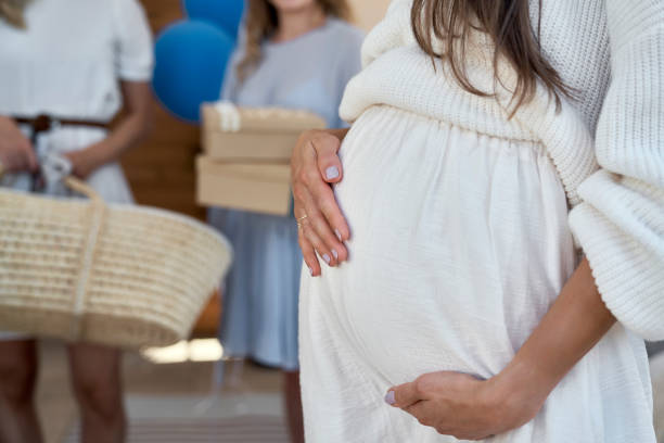 Part of woman in pregnant with her friend at baby shower stock photo