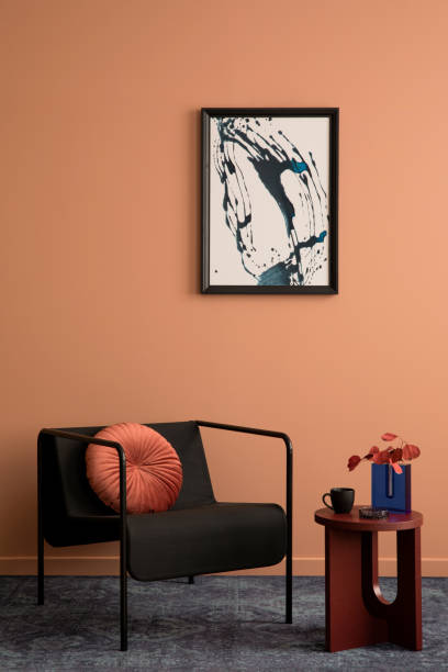 モックアップポスターフレーム、黒いアームチェア、丸いコーヒーテーブル、ドライフラワーの花瓶、ピンクの枕のネイビーラグ、パーソナルアクセサリーを備えたミニマルなリビングルー� - showcase interior home decorating chair pink ストックフォトと画像