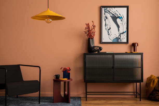 モックアップポスターフレーム、ガラスサイドボード、黄色のランプ、格子縞、カーペット、黒いアームチェア、ドライフラワーと個人用アクセサリーの花瓶を持つ居心地の良いリビングル� - showcase interior home decorating chair pink ストックフォトと画像