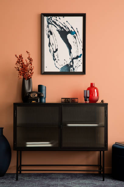 モックアップポスターフレーム、ガラスサイドボード、赤いドライフラワーの黒い花瓶、スタイリッシュなランプ、パーソナルアクセサリーを備えた居心地の良いリビングルームのインテリ� - showcase interior home decorating chair pink ストックフォトと画像