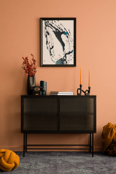 モックアップポスターフレーム、ガラスサイドボード、赤いドライフラワーの黒い花瓶、スタイリッシュなランプ、パーソナルアクセサリーを備えた居心地の良いリビングルームのインテリ� - showcase interior home decorating chair pink ストックフォトと画像