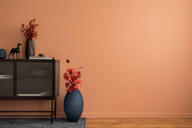 コピー用スペース、黒いサイドボード、赤いドライフラワーとネイビーの花瓶、本、犬、カーペット、パーソナルアクセサリーを持つアイビングルームインテリアのクリエイティブな構成。� - showcase interior home decorating chair pink ストックフォトと画像