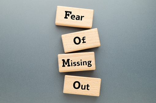 Fear of Missing Out text on wooden blocks, FOMO mental health, FOMO marketing, topic
