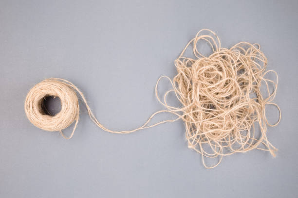 The tangled rope concept with a clew as the beginning of things unravels the confused rope, and mental problem, or the more you solve, the more busy concept