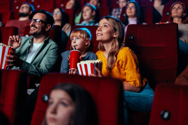 Family enjoying movie in theater. stock photo