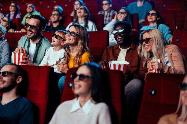 Excited crowd watching 3D movie in theater. stock photo