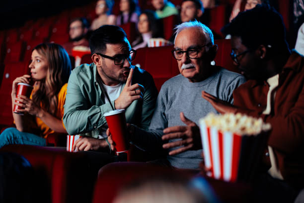 istock People silencing senior man in cinema. 1466383412