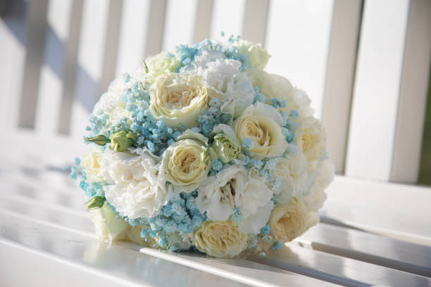 Amazing wedding bouquet made of roses, hydrangeas and lavender laying on the white wooden ground.