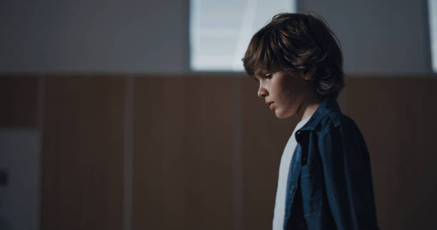 istock Thoughtful schoolboy walking empty corridor alone. Loneliness in school concept. 1466386908