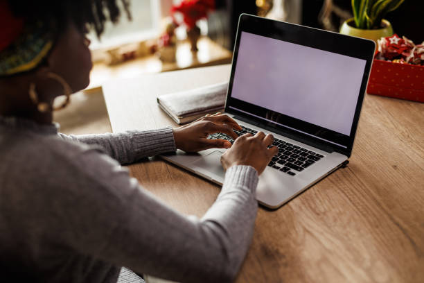 istock Young woman typing data on a laptop with blank, white screen 1466388352