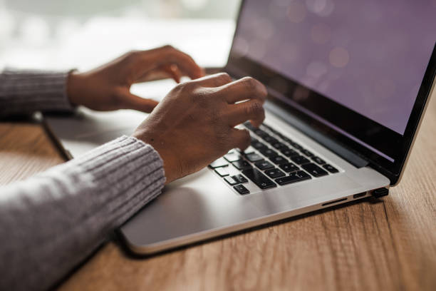 istock Young woman typing data on a laptop with blank, white screen 1466388358