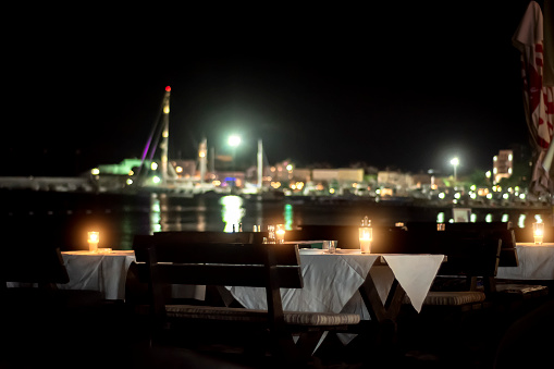 Table with candles on the beach of the evening cafe,