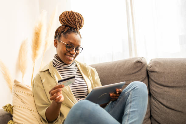 istock Smiling young African American woman using credit card 1466389986