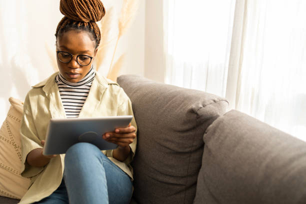 istock Young African American woman using digital tablet at home 1466390506