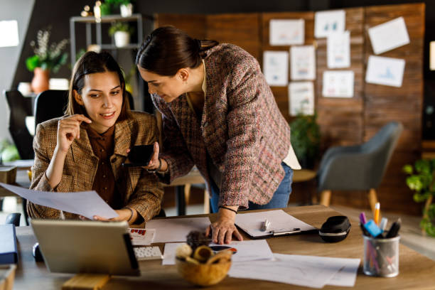 istock Two businesswomen on a conference call analyzing document and discussing strategies 1466392141