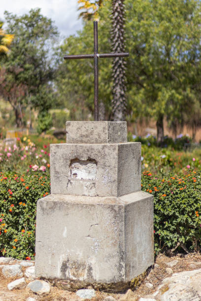 small statue of a cross made of cement and iron, surrounded by various vegetation such as flowers, trees and stones in the campo santo, yungay, ancash - peru. - rocio monasterio imagens e fotografias de stock