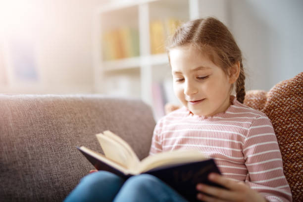 istock Pretty girl have a rest on the cozy couch with interesting book 1466394030