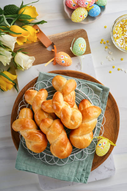 istock Easter breakfast Holliday concept. Easter bunny buns rolls with cinnamon made from yeast dough with orange glaze, easter decorations, colored eggs on white spring background. Easter Holliday card. 1466396482