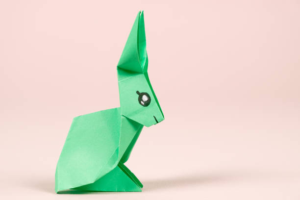 Concertina white paper bunny decoration on black background with copy space