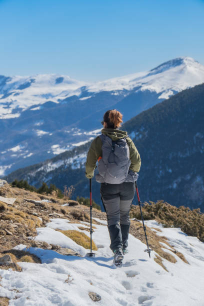 istock female hiker walking on snowy mountain 1466399579