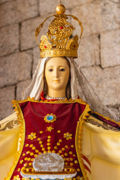 small statue of the virgin mary with accessories and tunic in cherry and yellow on an altar - rocio monasterio imagens e fotografias de stock