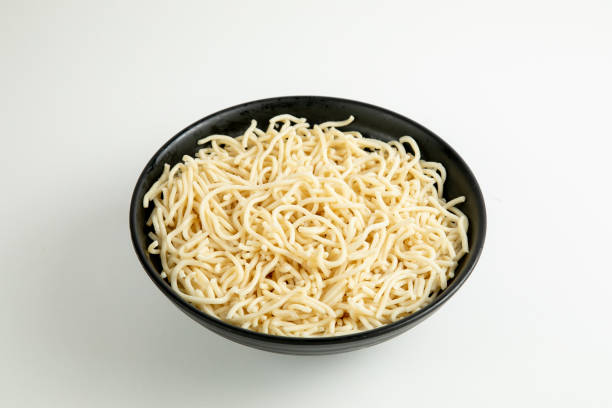 istock yellow noodle in a black bowl isolated on white background 1466405867