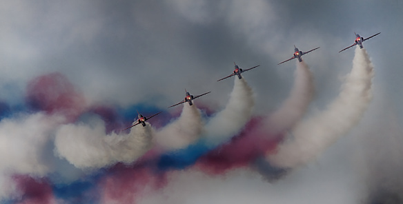 Red Arrows perform acrobatic move with coloured smoke behind