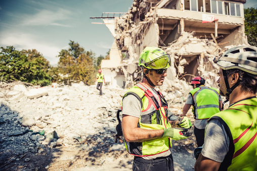 Rescuer search trough ruins of building with help of rescue dog