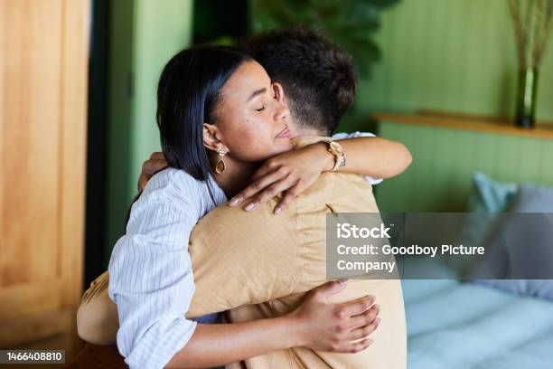 Loving Woman Hugging Her Upset Husband In Their Bedroom At Home Stock Photo - Download Image Now