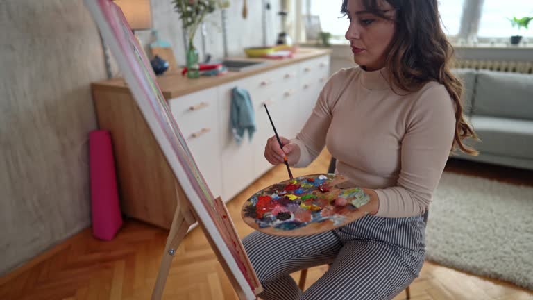 Female artist painting at home