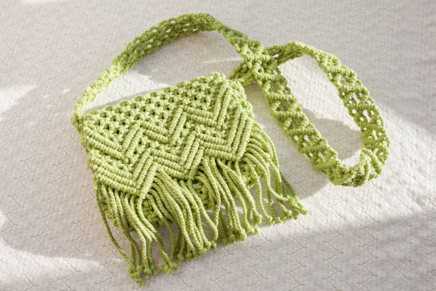 Handmade macrame cotton ross-body bag. Eco bag for women from cotton rope. Scandinavian style bag.  Light green color, sustainable fashion accessories. Details. Close up image stock photo