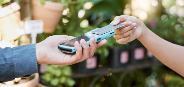 istock Hands, payment and credit card with a customer using NFC technology to make a purchase at a florist. Money, finance and retail with a female consumer shopping for plants or flowers for gardening 1466409721