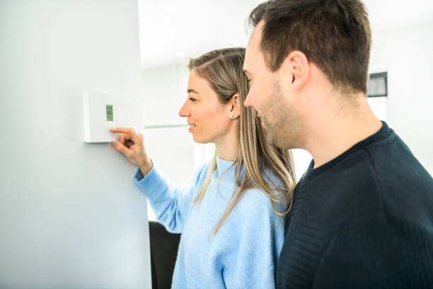 istock couple set the thermostat at home house 1466410310