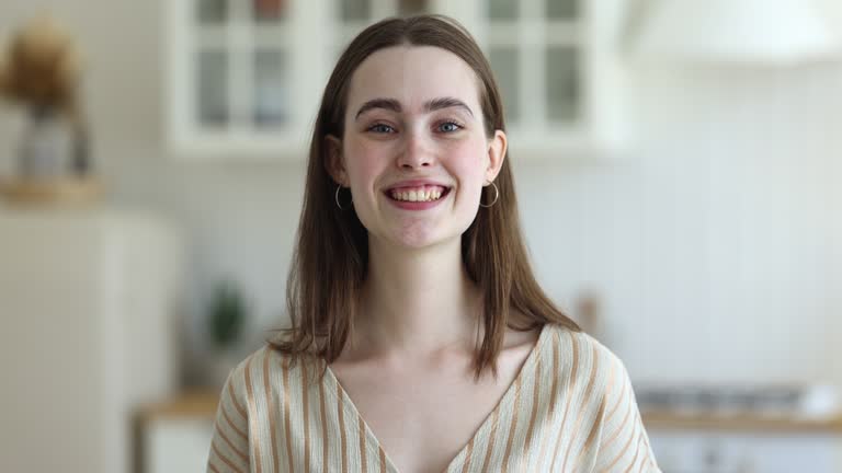 Headshot portrait of happy young woman pose in kitchen